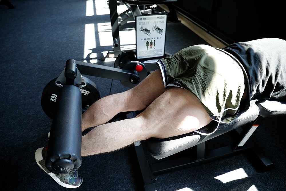 Сгибание ног в тренажере: варианты стоя и лежа, польза и вред упражнения, чем можно заменить